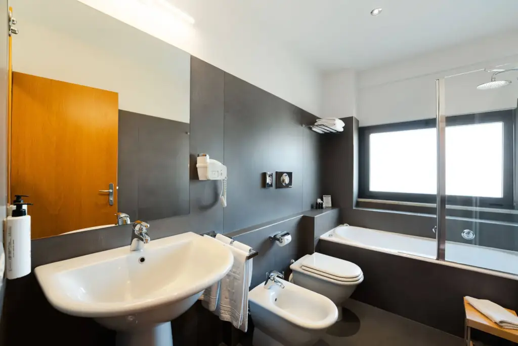 Bagno moderno con vasca all'Hotel Touring.
